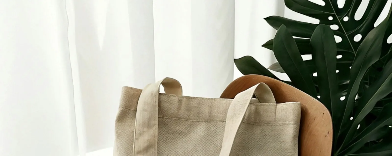 A canvas tote resting on a chair in a bright room