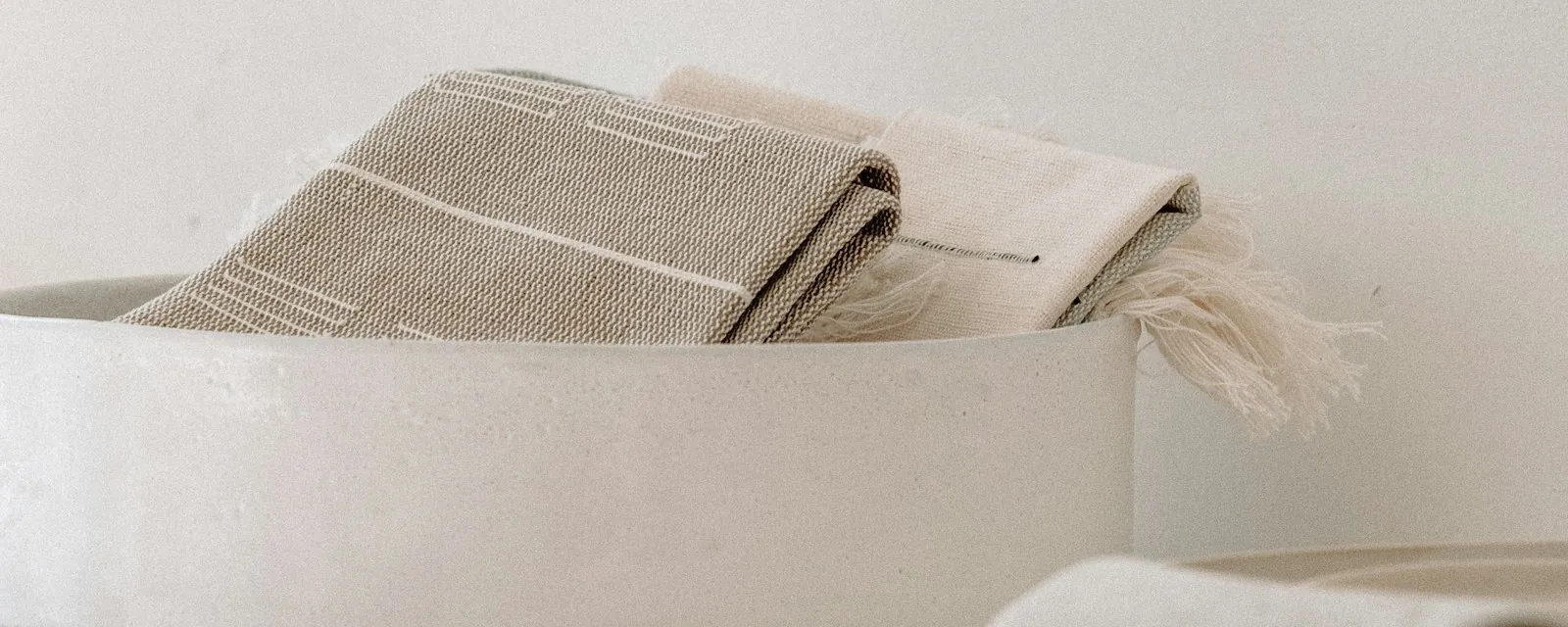 Folded textiles stacked in soft neutral tones